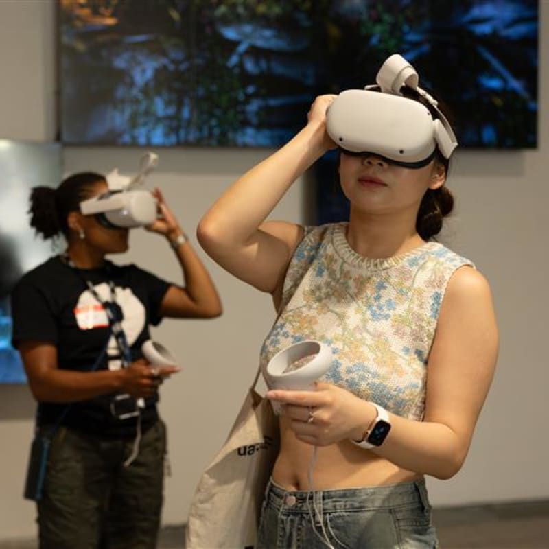 Students wearing wearable virtual reality head-sets in a gallery space.