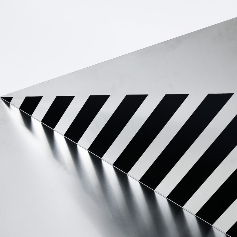 A black and white striped triangle reflects a shadow