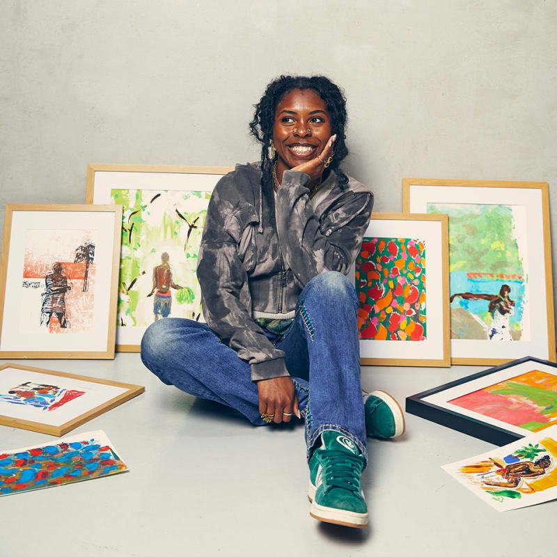 Davinia Clarke sits on the floor surrounded by her framed prints.