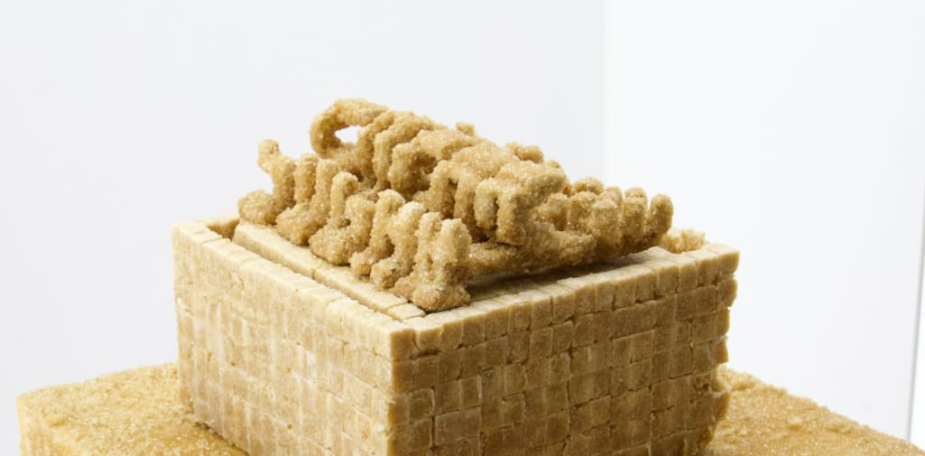 sand colour granules sculpture representing glyphs