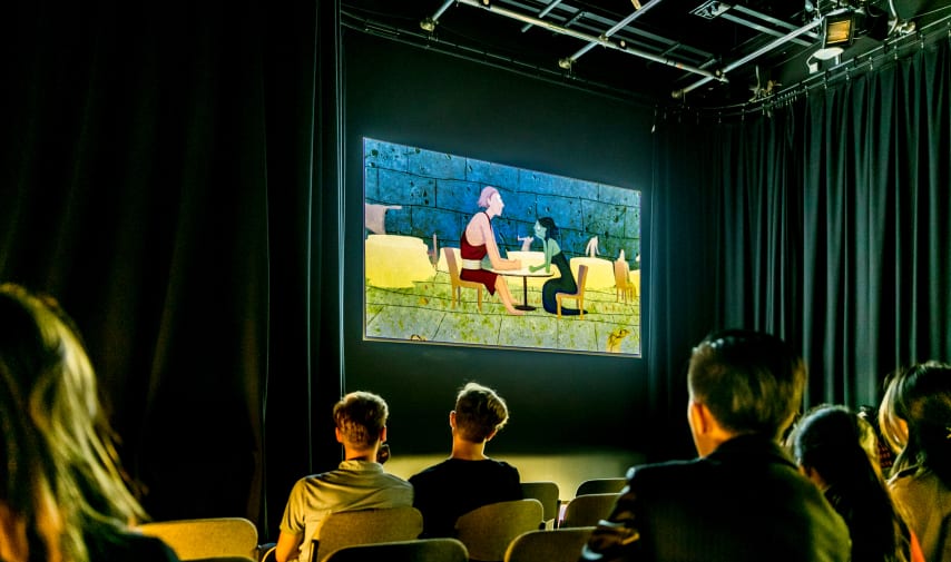 People sat in a cinema watching an animated film