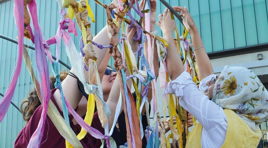 People threading ribbons