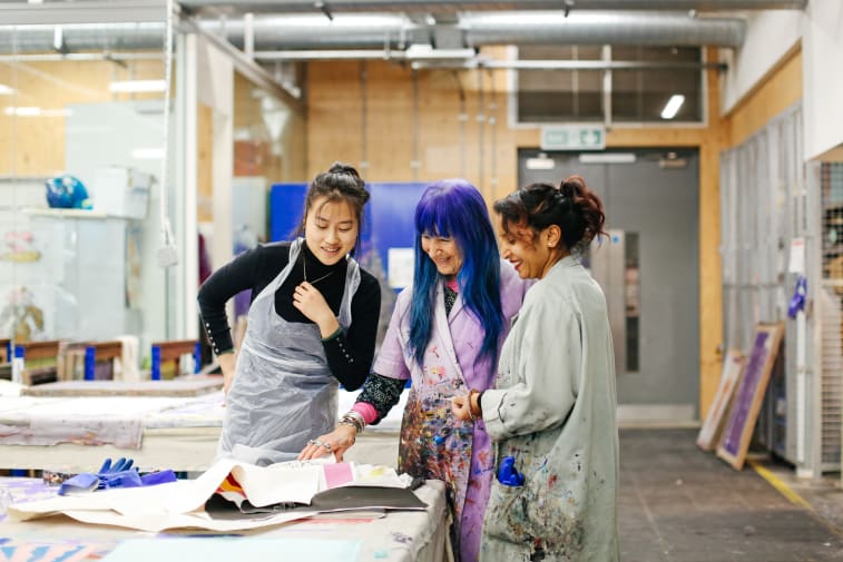 Students working with technician in the letterpress workshop 