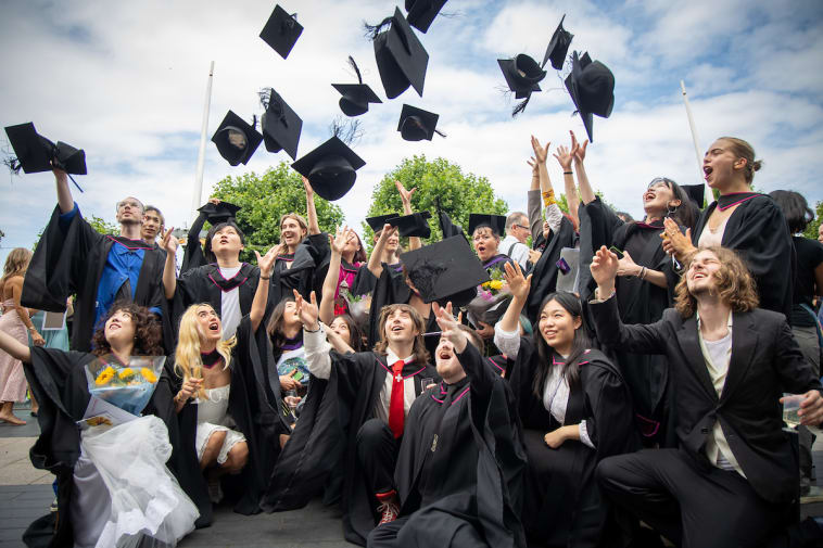 A group of graduates throwing their hats in the air.