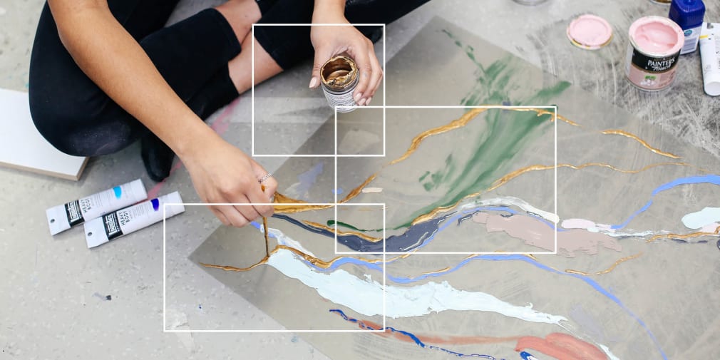 Person sat on floor painting an abstract painting