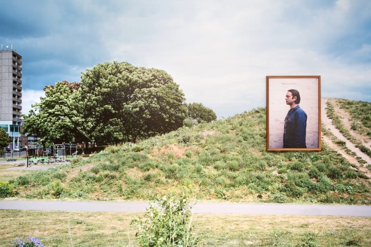 Green space with a large photography installation of a man.   