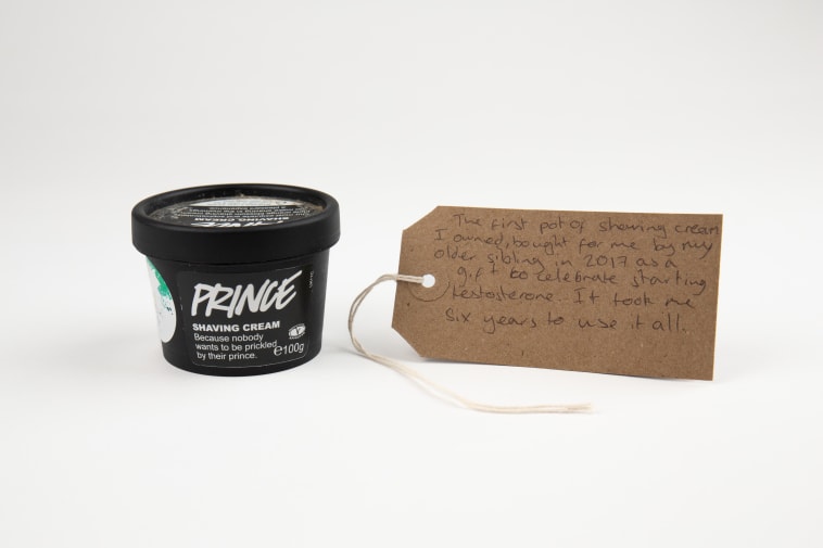 A pot of shaving cream with a handwritten label attached with the words 