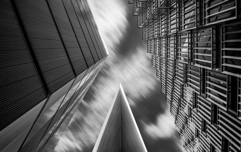 Black and white photograph showing a shot upwards at three high-rise buildings.