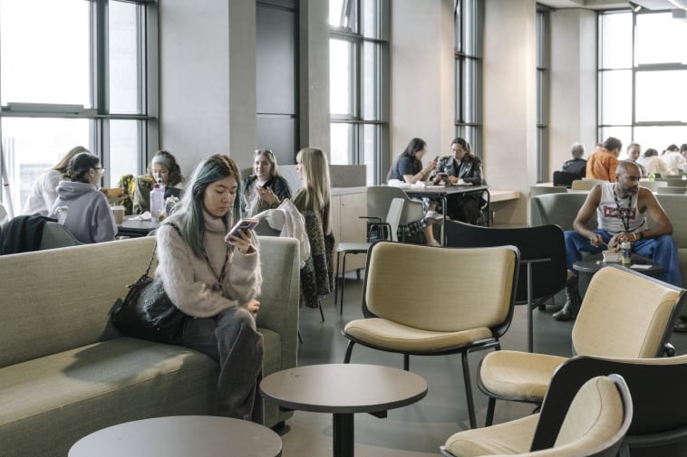 People sitting and chatting with tables and chairs.