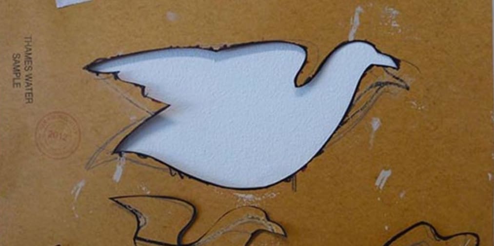A dove silhouette cut out of what looks like wood or cardboard material sheet.