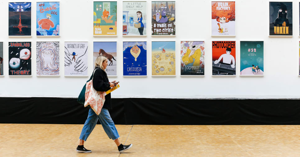 Student walking along a corridor with animated posters on the wall