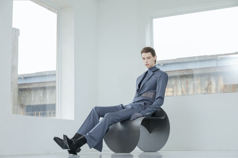 Male model in tailored blue suit in an empty white room