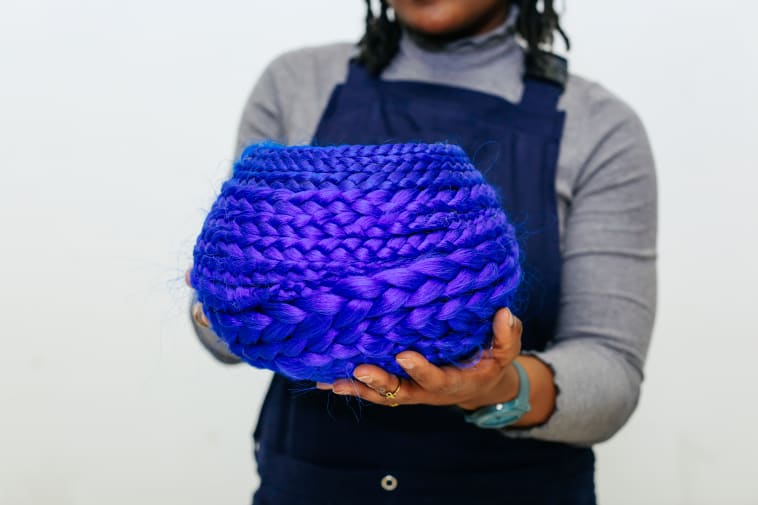 Person holding a purple woven bowl