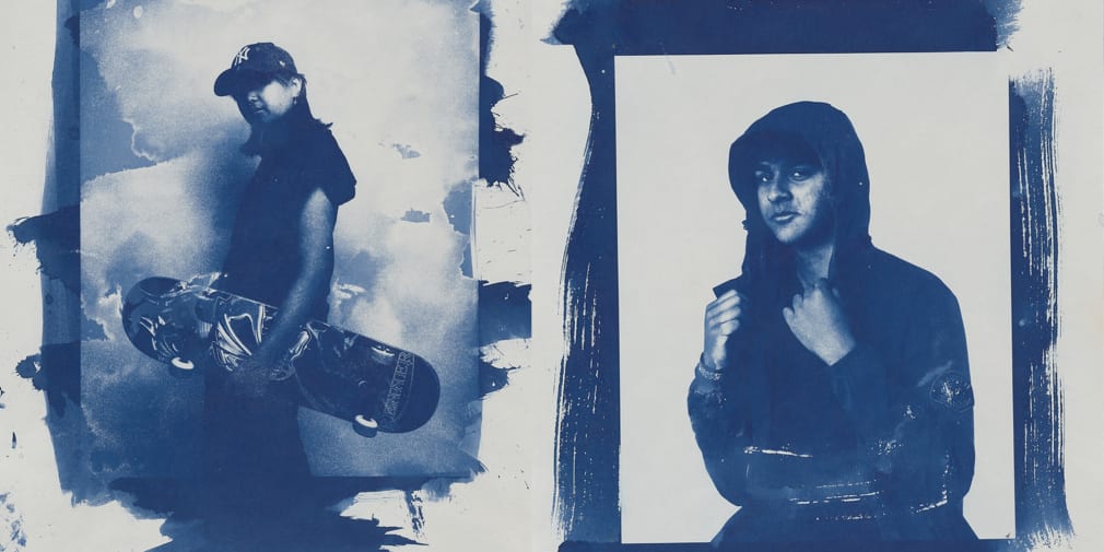 2 cyanotype portraits, left portrait is of a student standing to the side with a skateboard in their hand. In the right hand portrait student is wearing a hoodie and looking into the camera. 