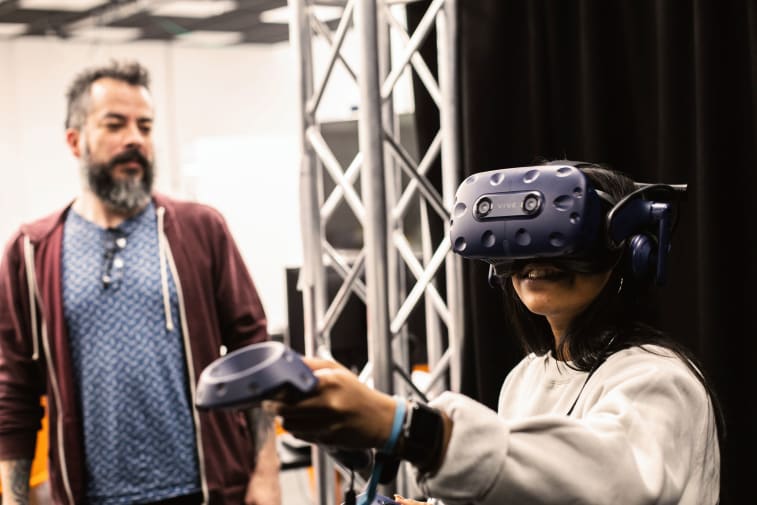 Technician standing next to a student wearing a virtual reality headset
