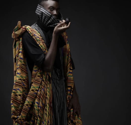 Person posing with African textiles and fabrics