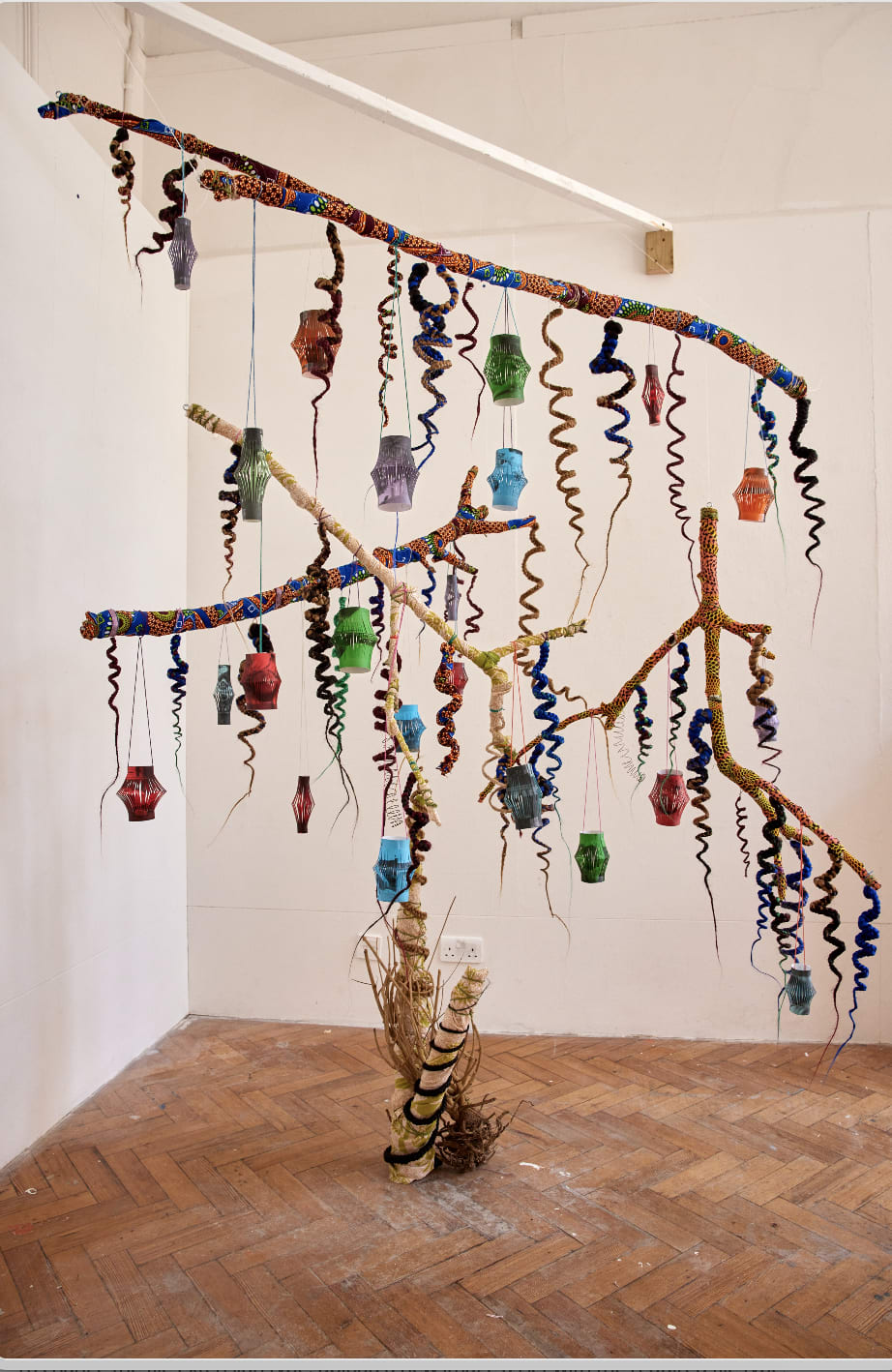  Branches in a tree-like structure from which hangs paper lanterns and paper coils