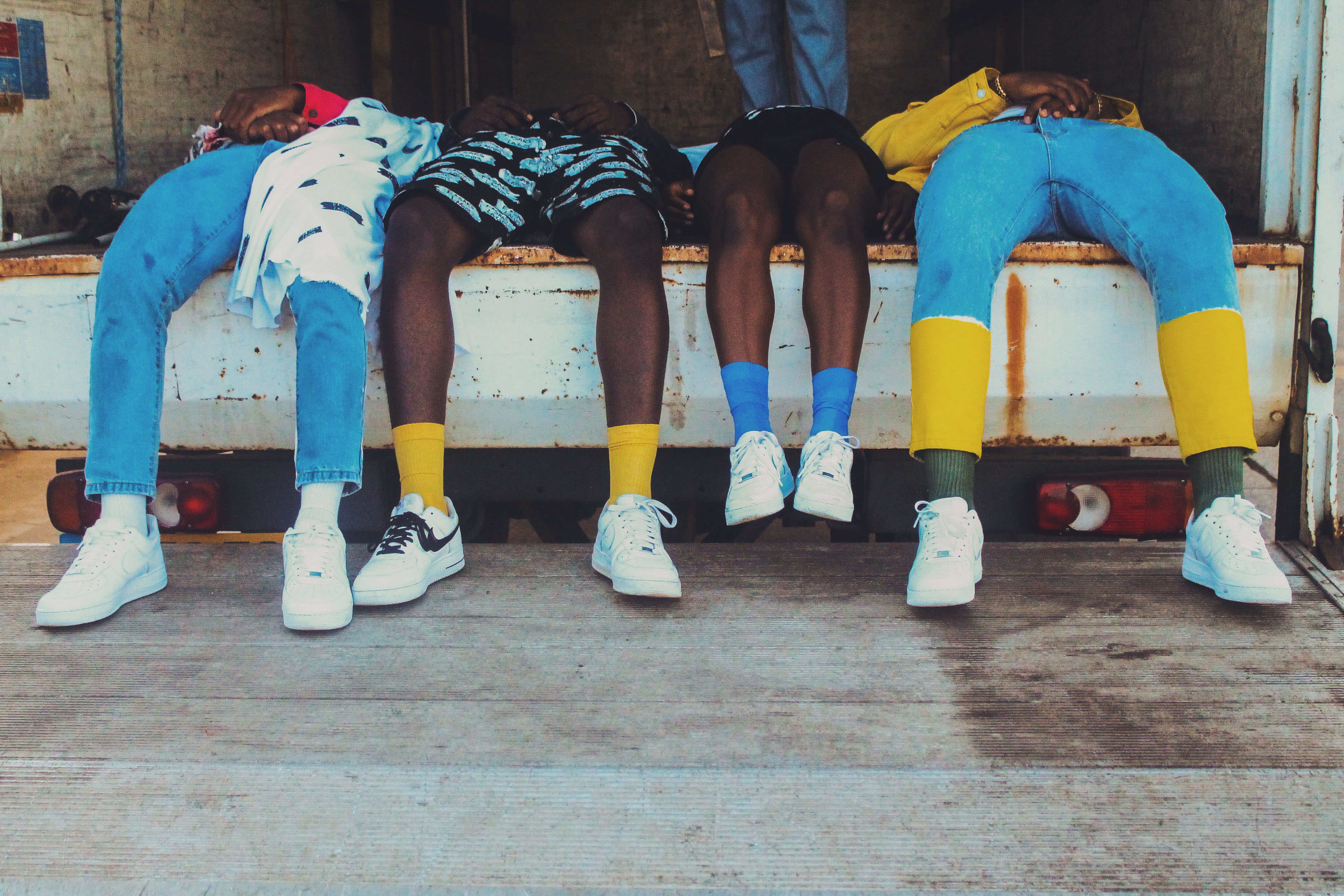 Four pairs of legs hanging off a seat