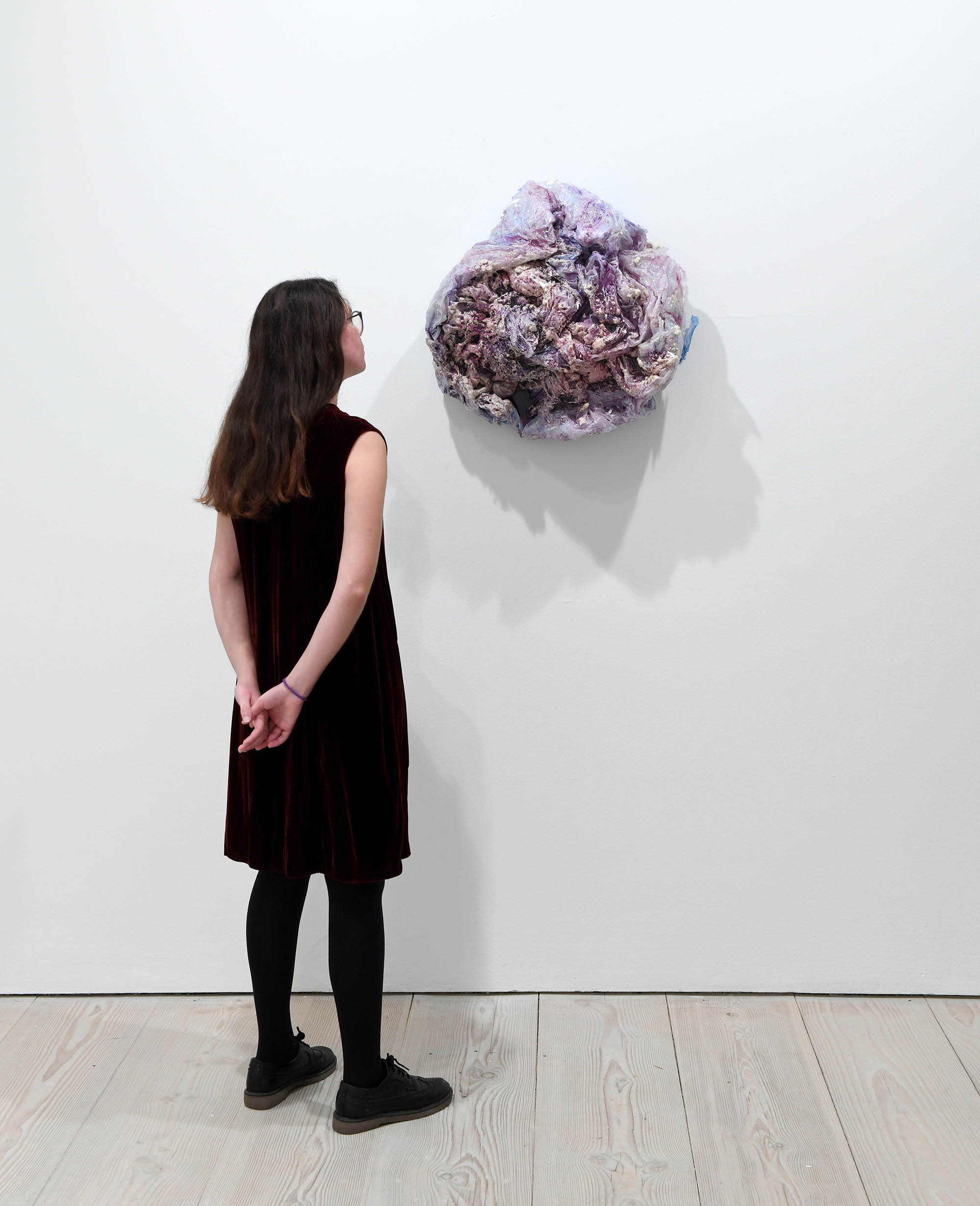 Person looking at purple circular object on wall