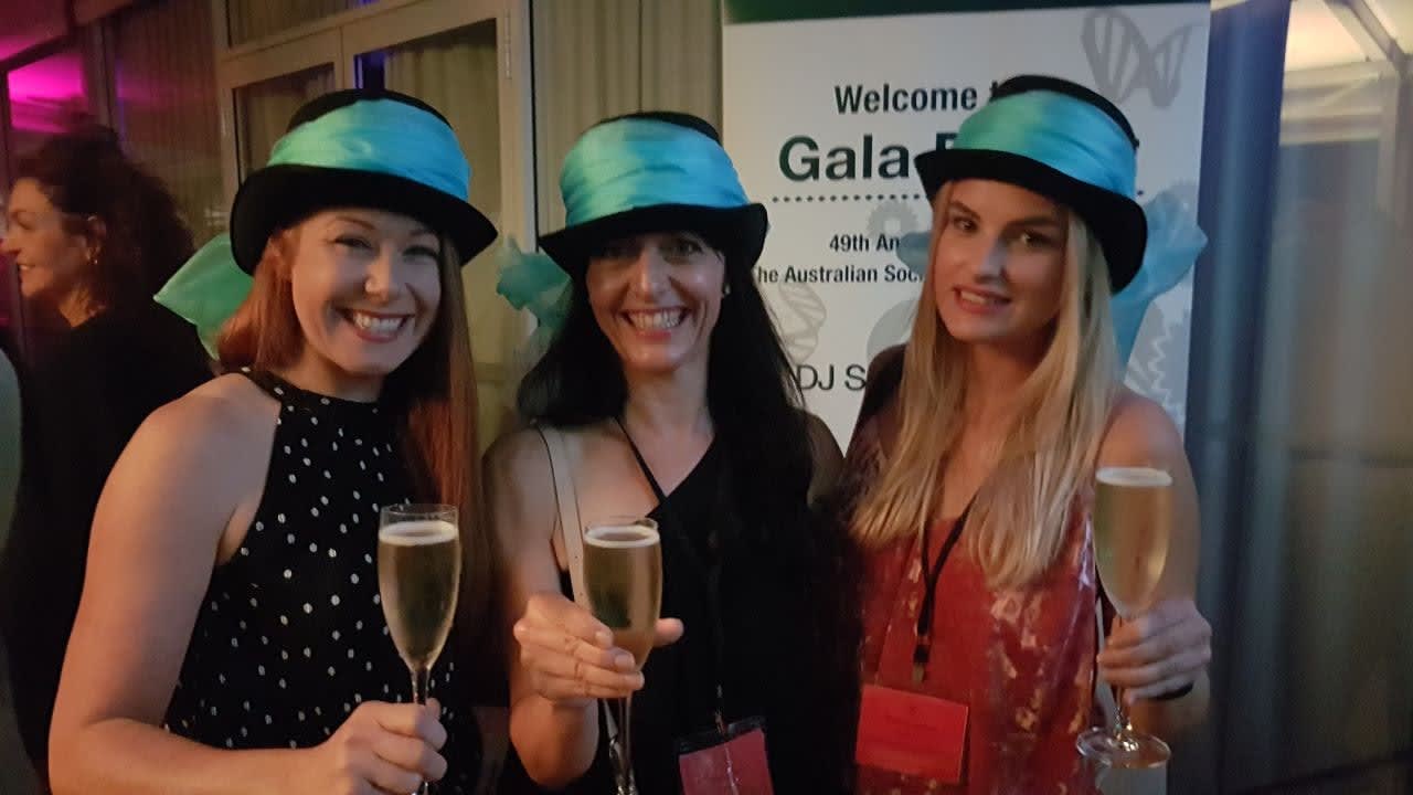 3 ladies at a conference with hats on