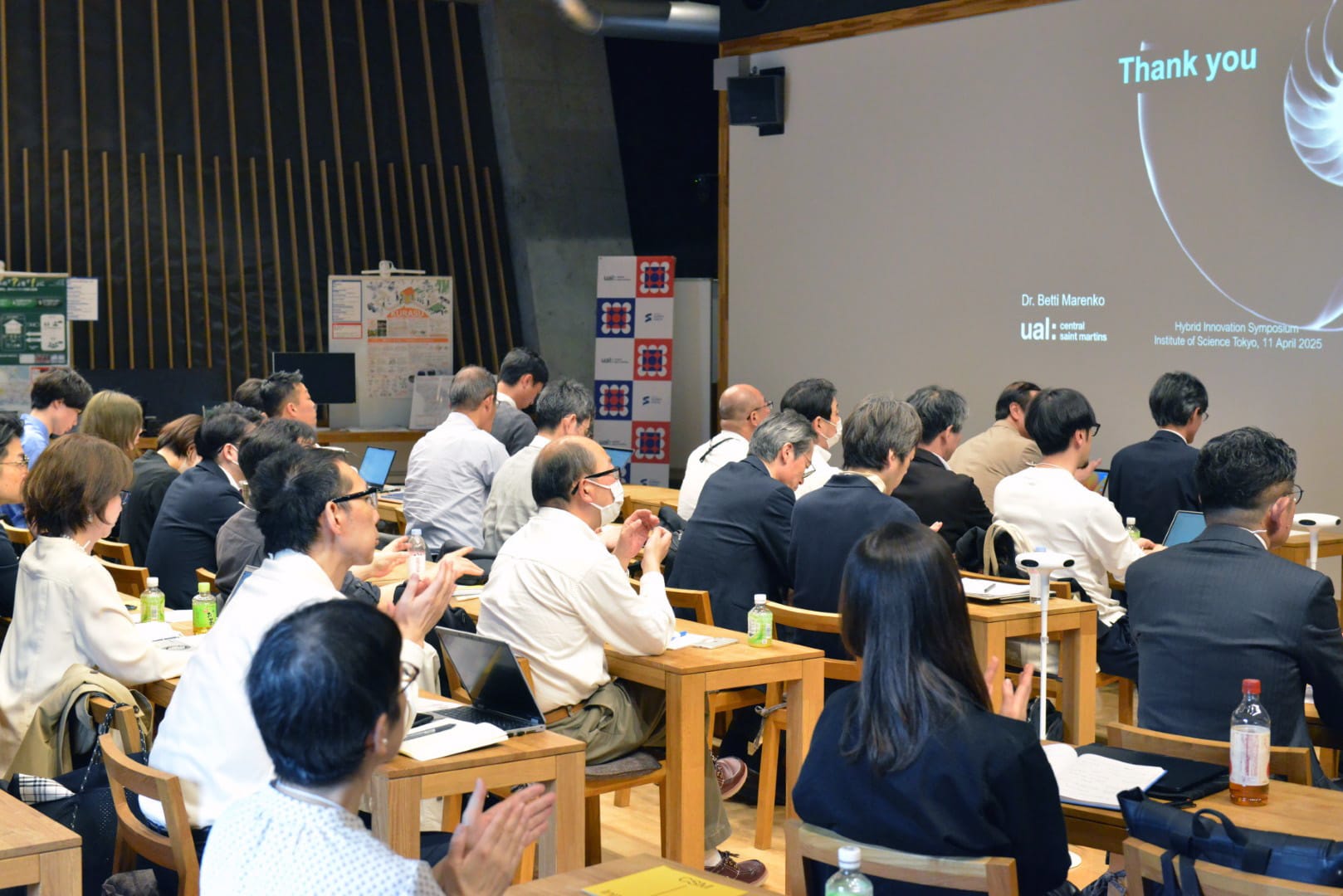 A group of professionals in a screening room at the Hybrid Innovation symposium.