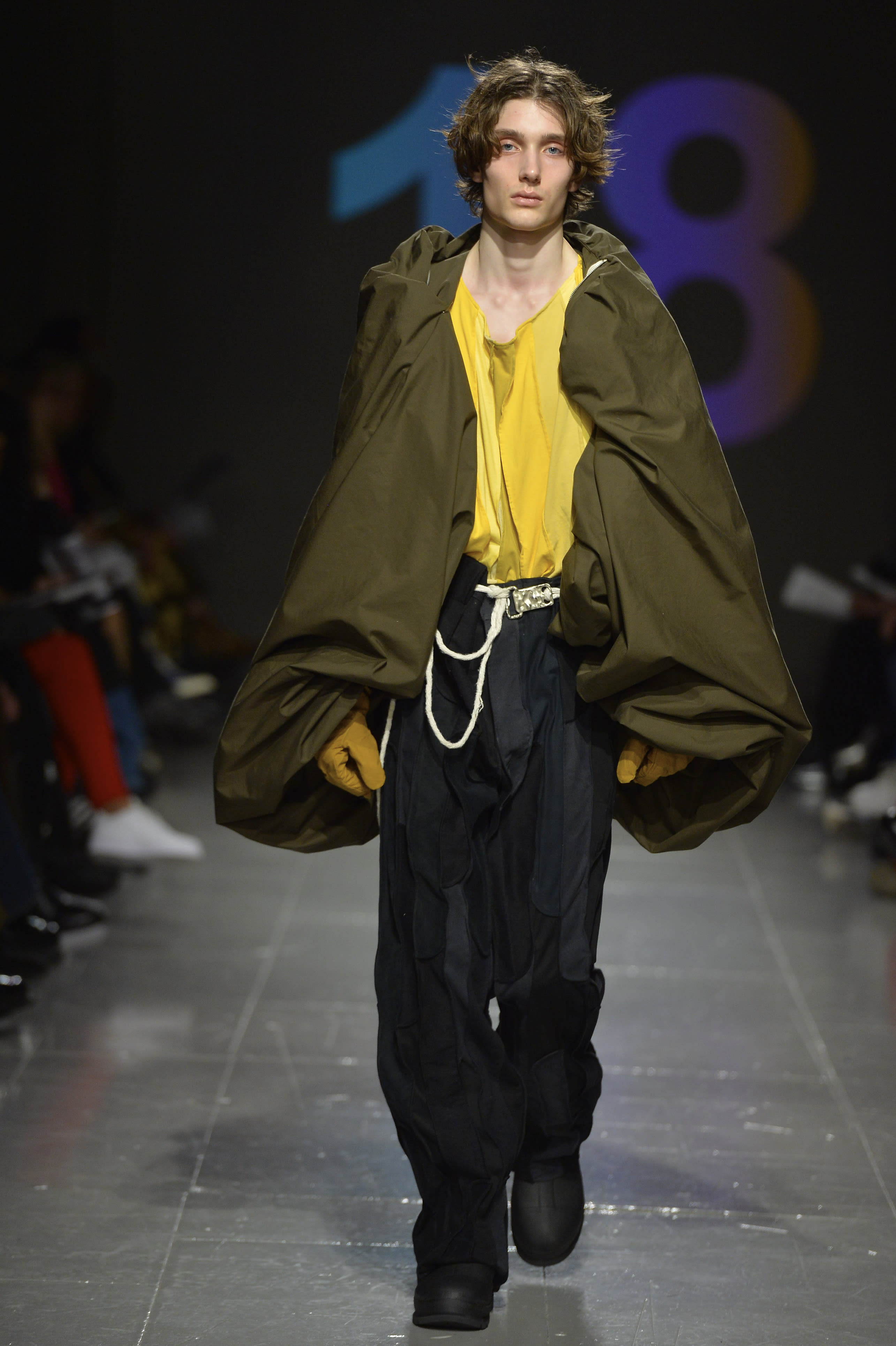 A model in draped and loose garments on the runway