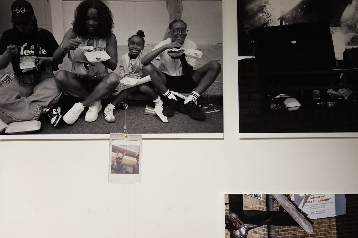 Sections from different photos, mainly a black and white shot of a smiling family sitting at ground level eating takeaway food 