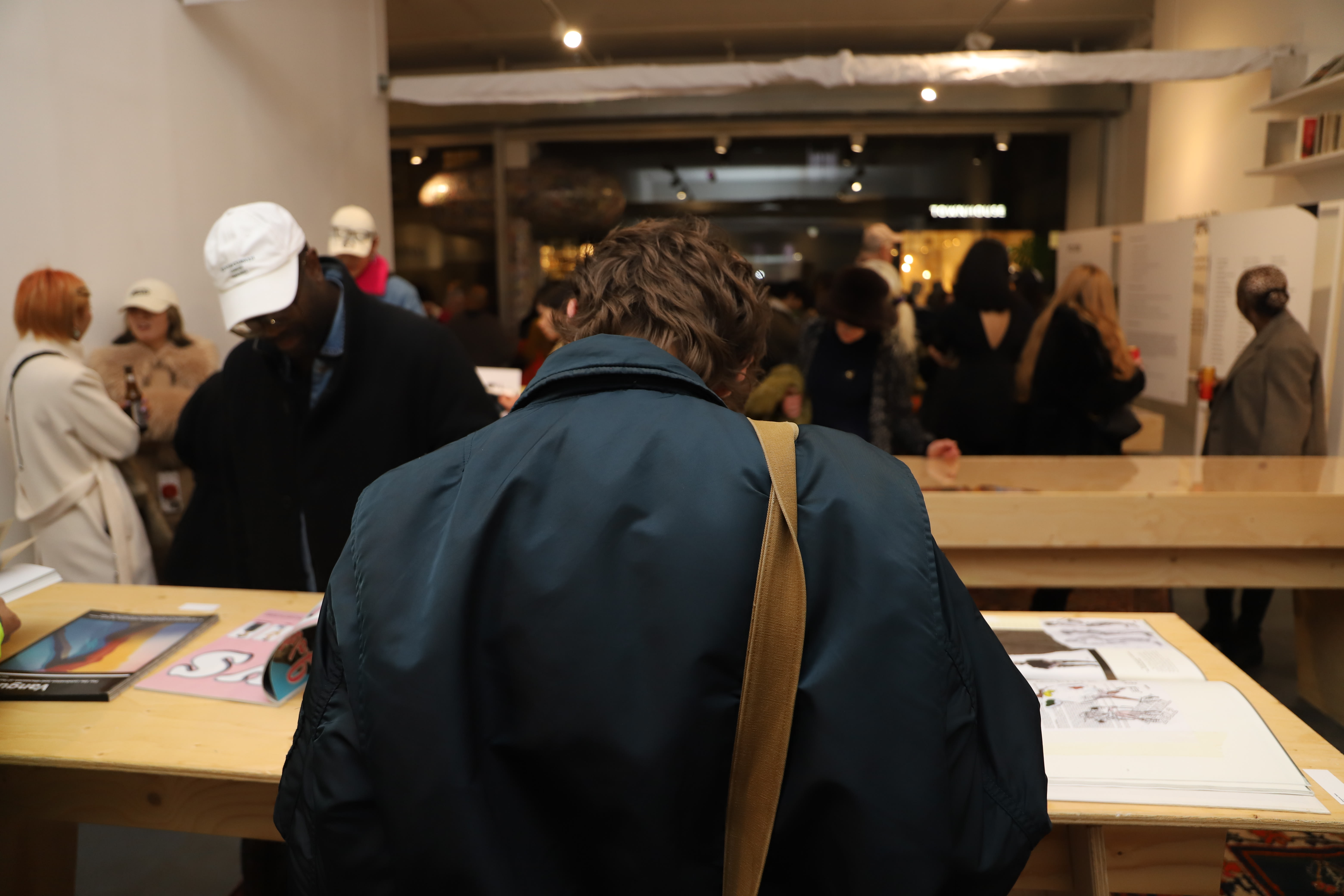 Guest from the back looking through a magazine in the exhibition.