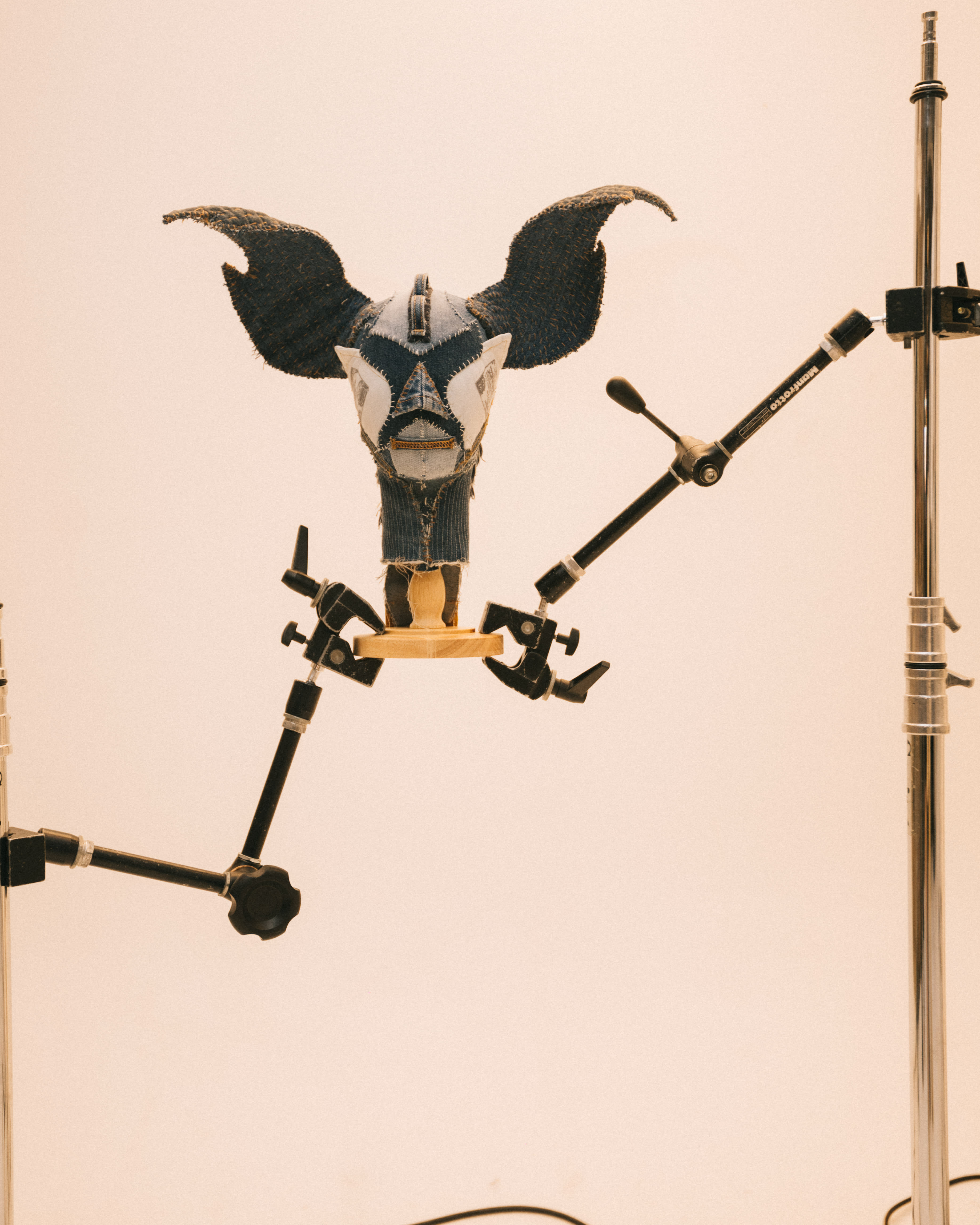 A wooden ornamental face mask against a white backdrop