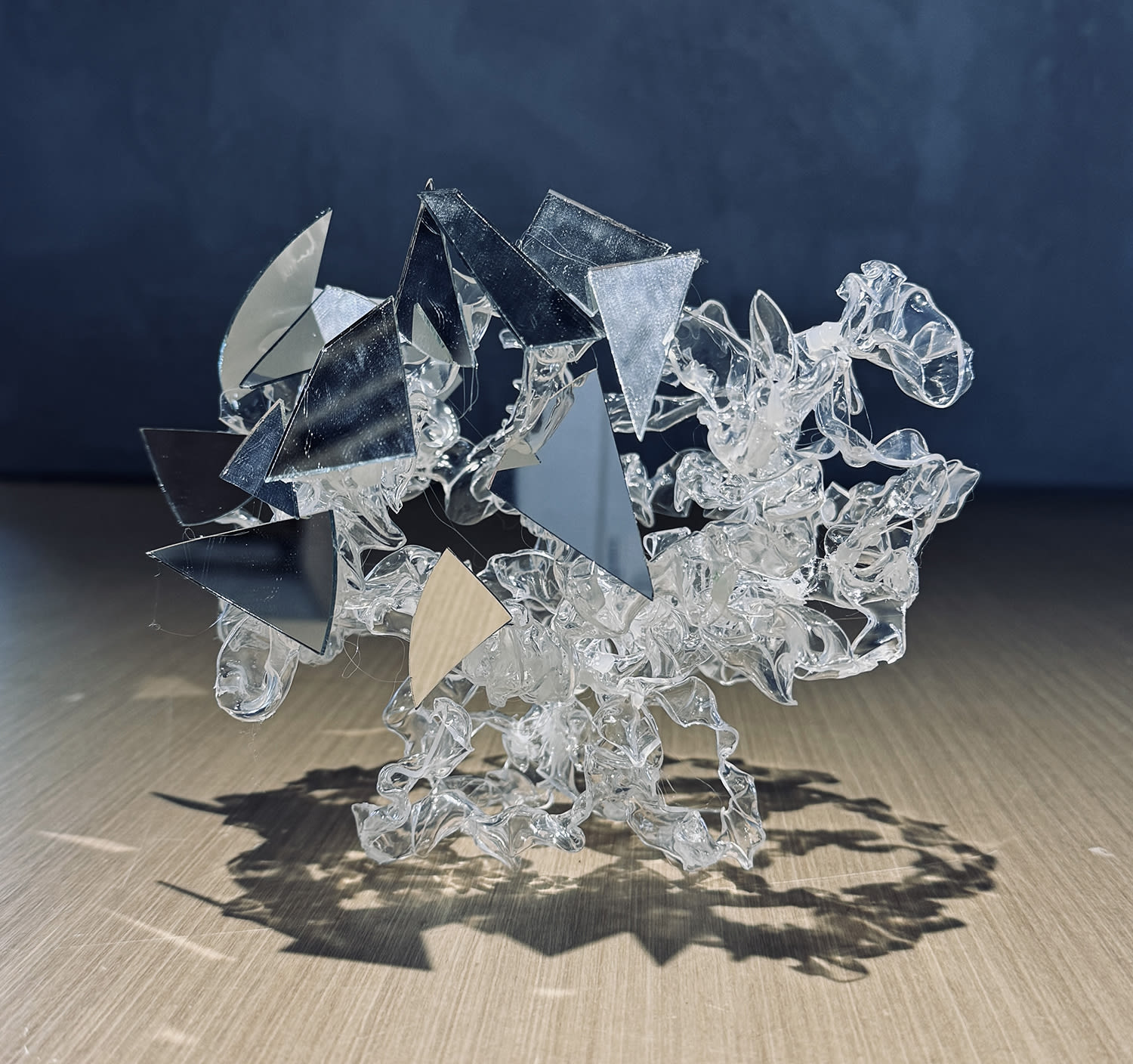 An abstract sculpture made of mirror shards and transparent materials.