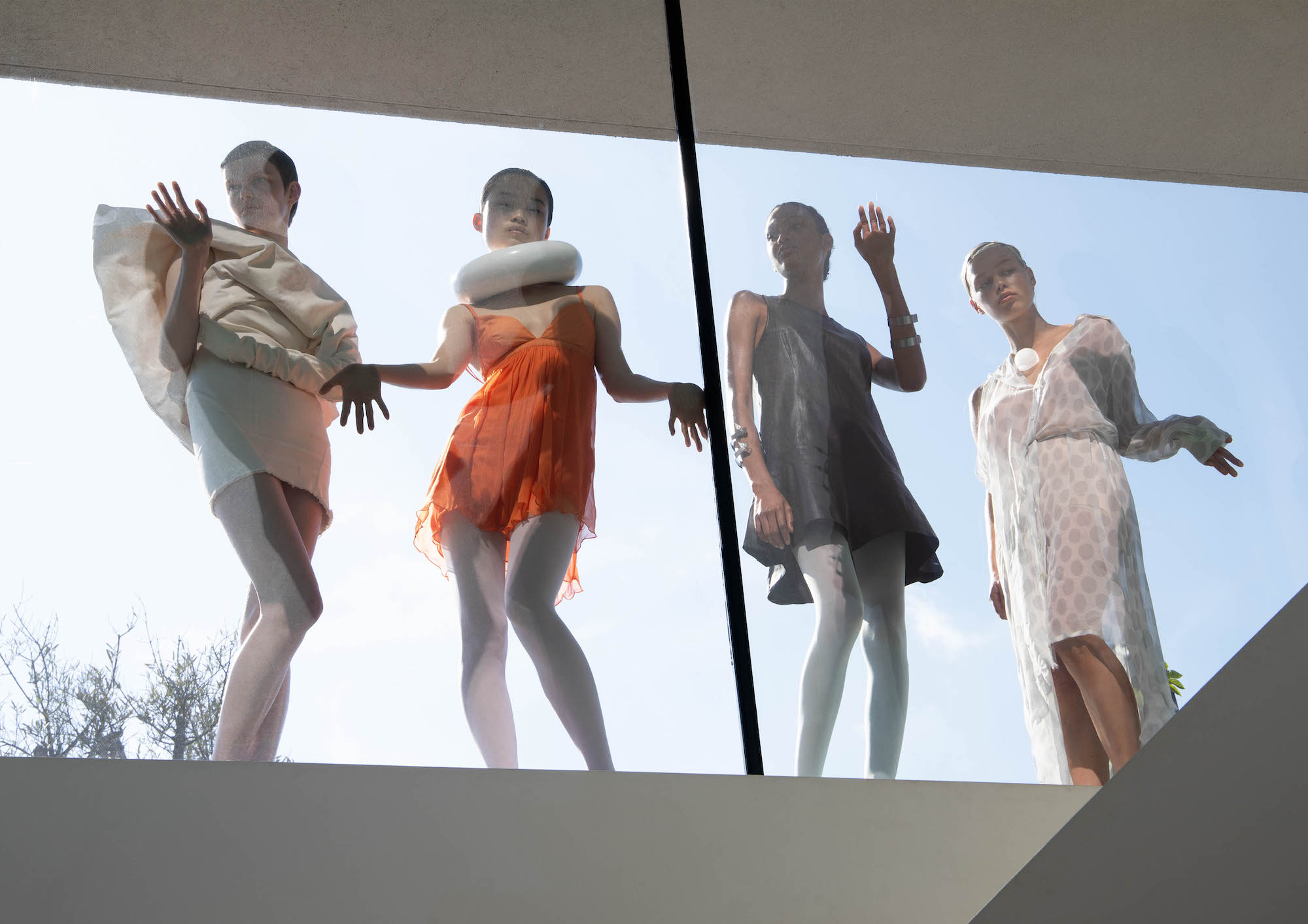 Four models looking through a window