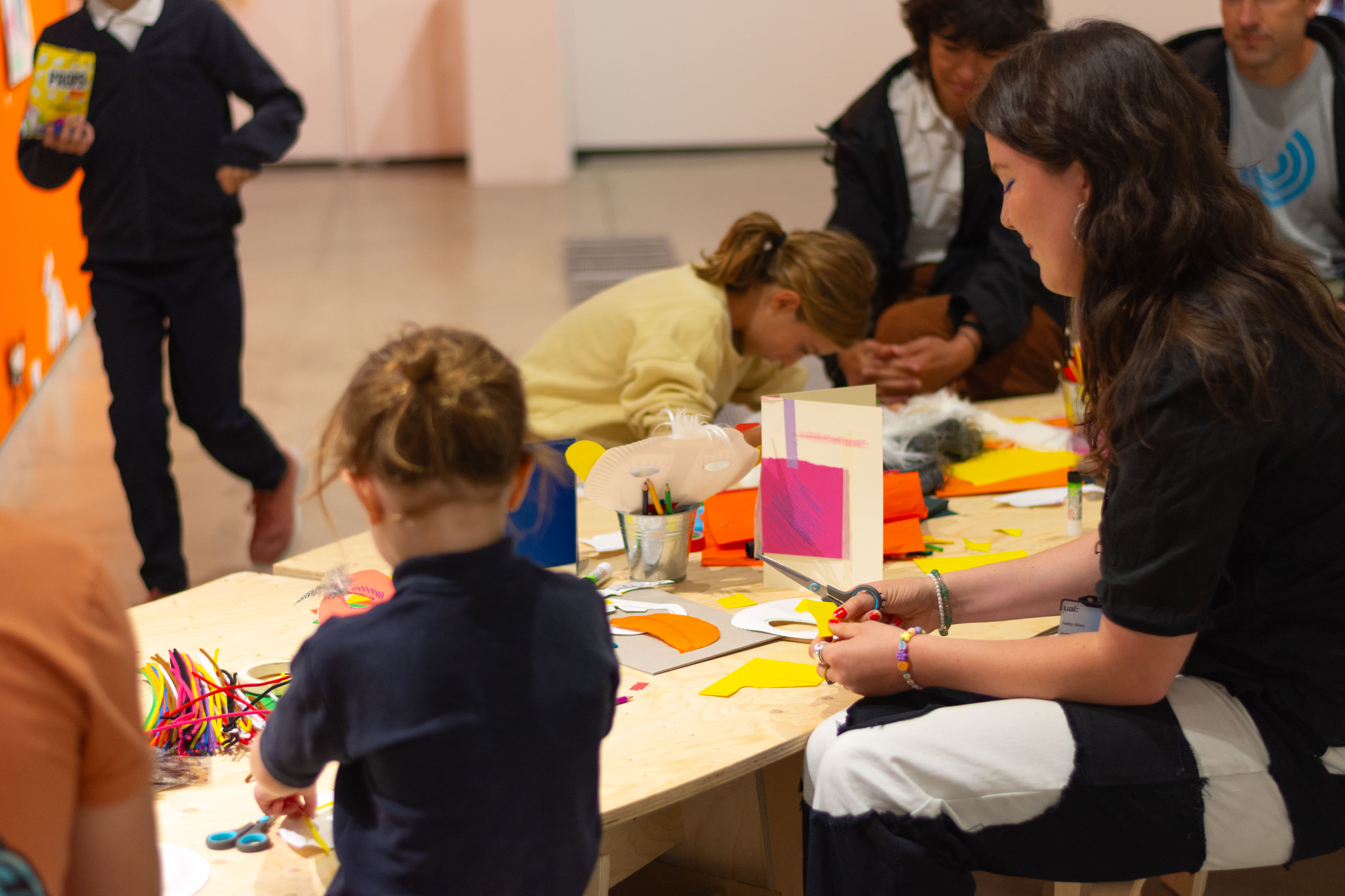 Children and adults doing creative activity at a table in the gallery