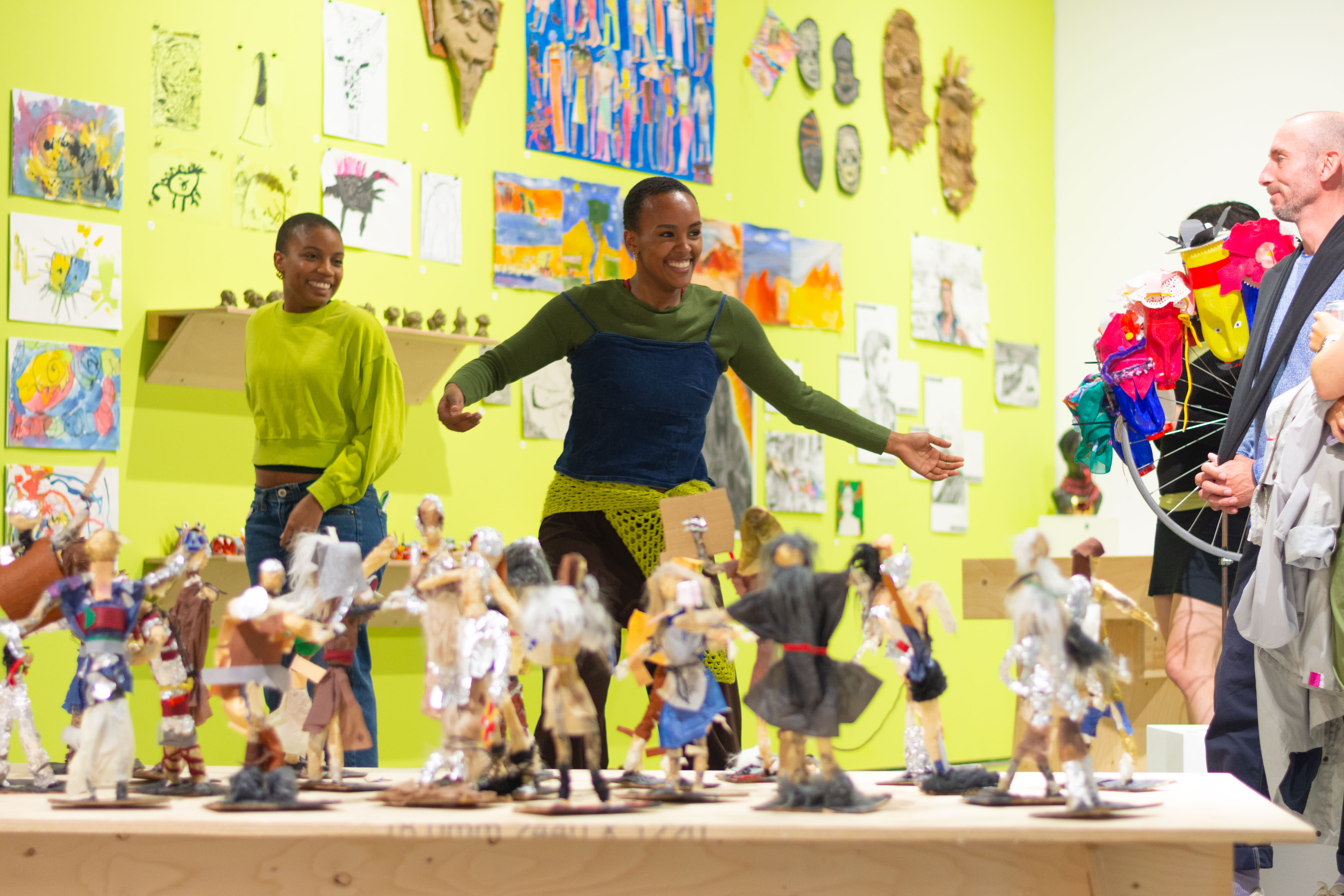 Smiling dancers in the gallery with artworks in the background and foreground