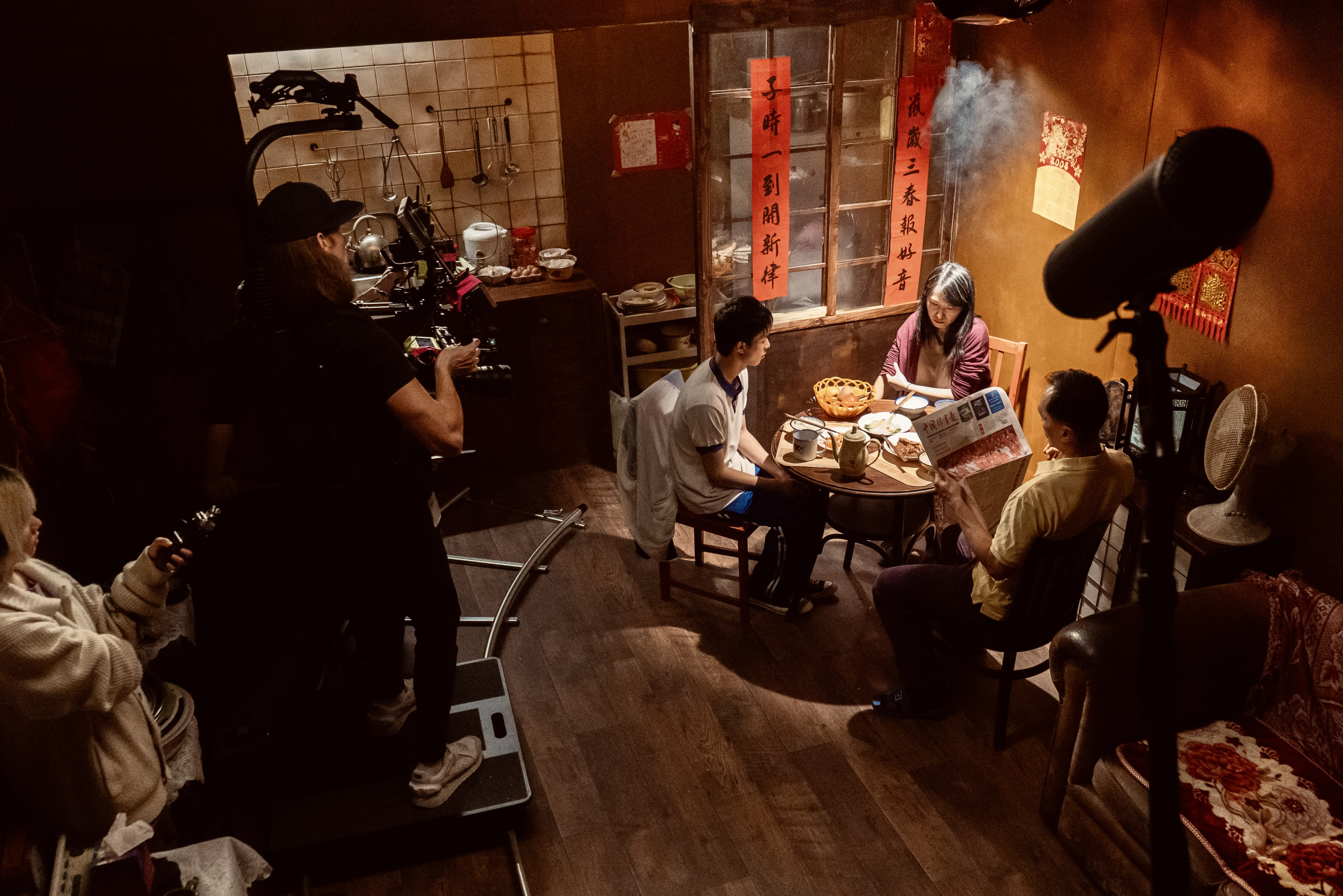 A film crew capturing a scene of a family at a table