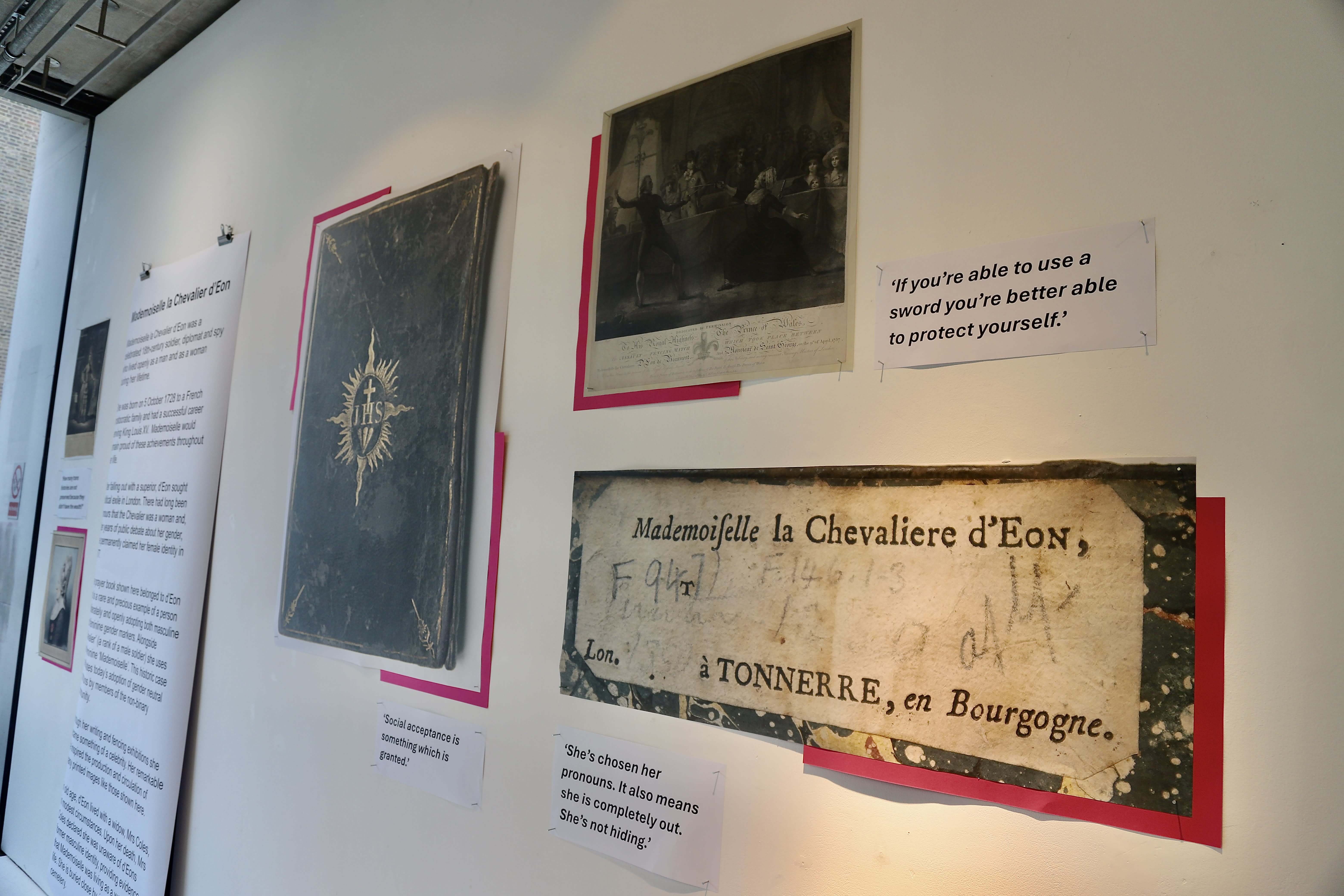 A selection of pinned up reproductions and text panels, including the book cover and nameplate