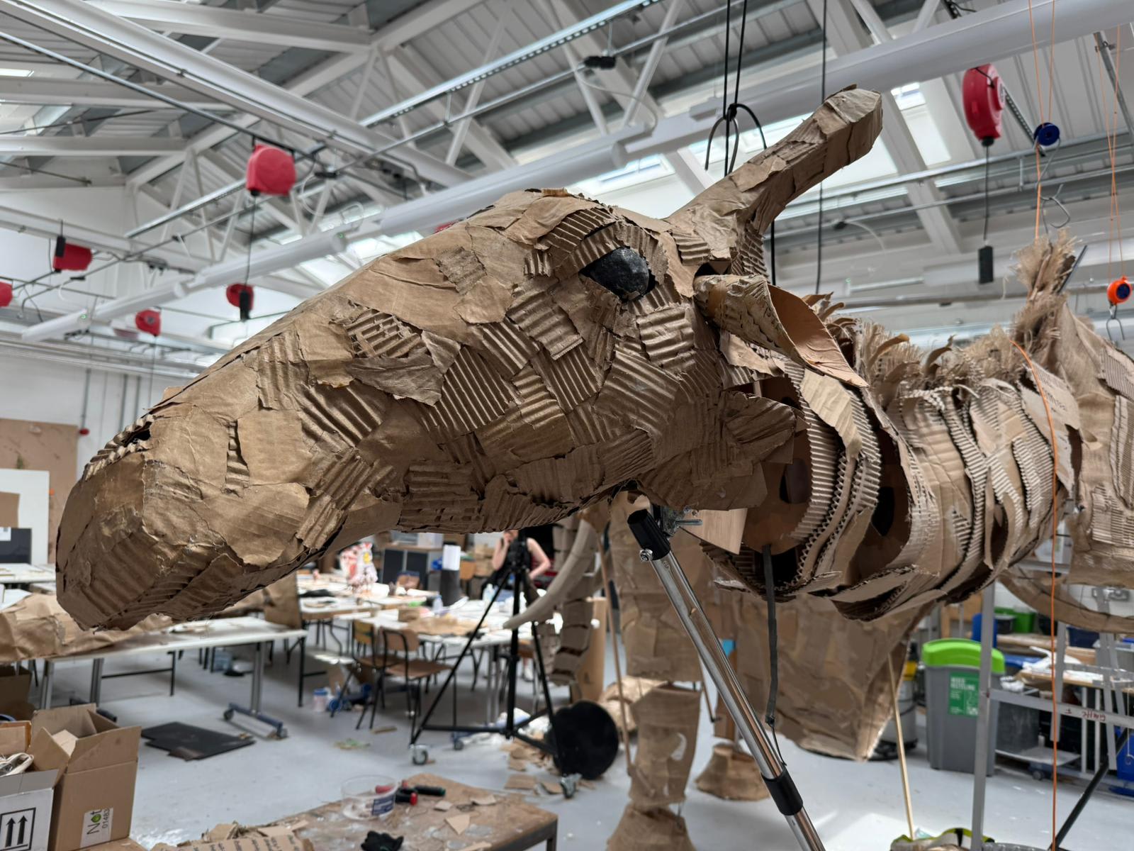 Model of a giraffes head created in cardboard.
