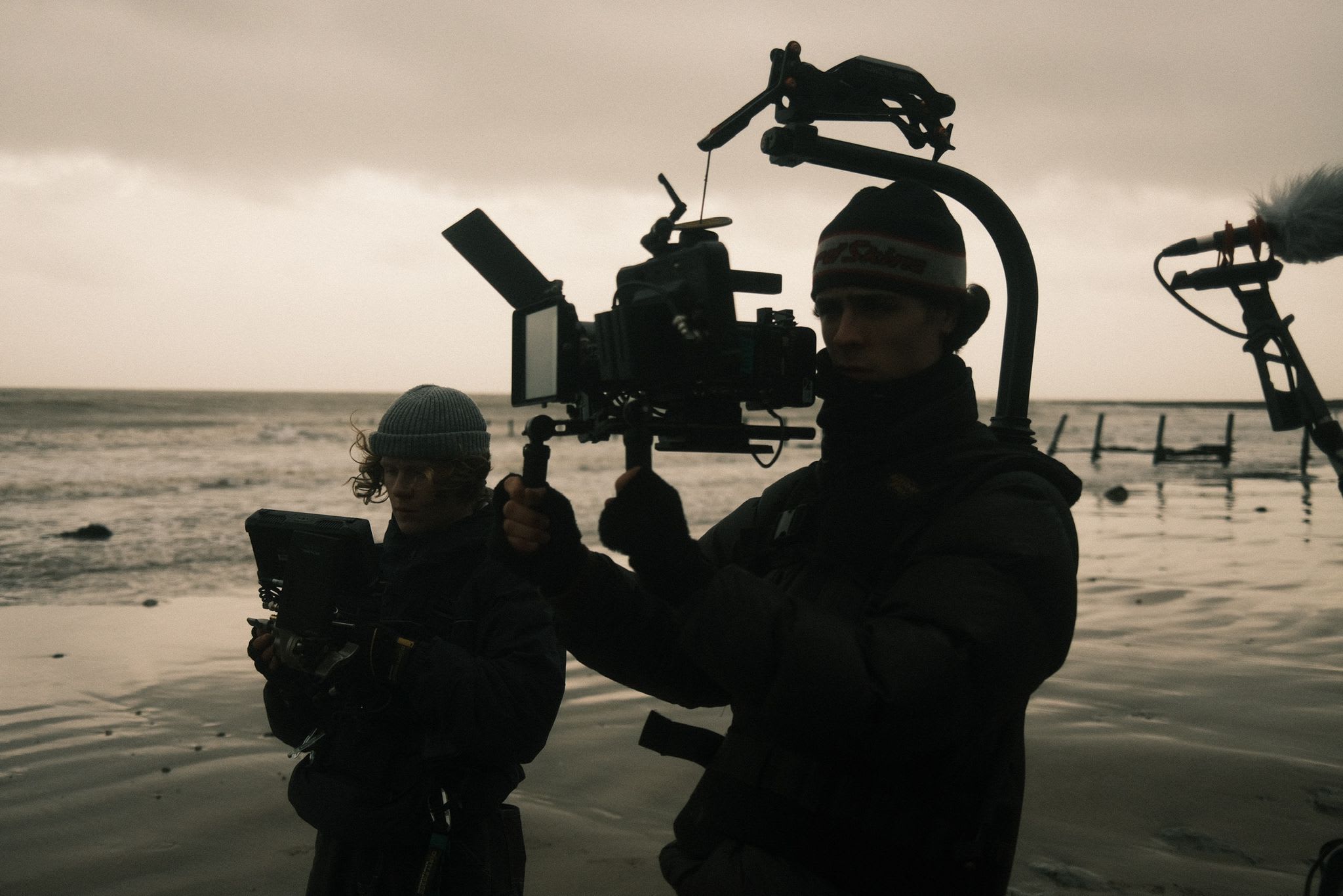 Two students in a film crew, one with a camera and one with a screen.
