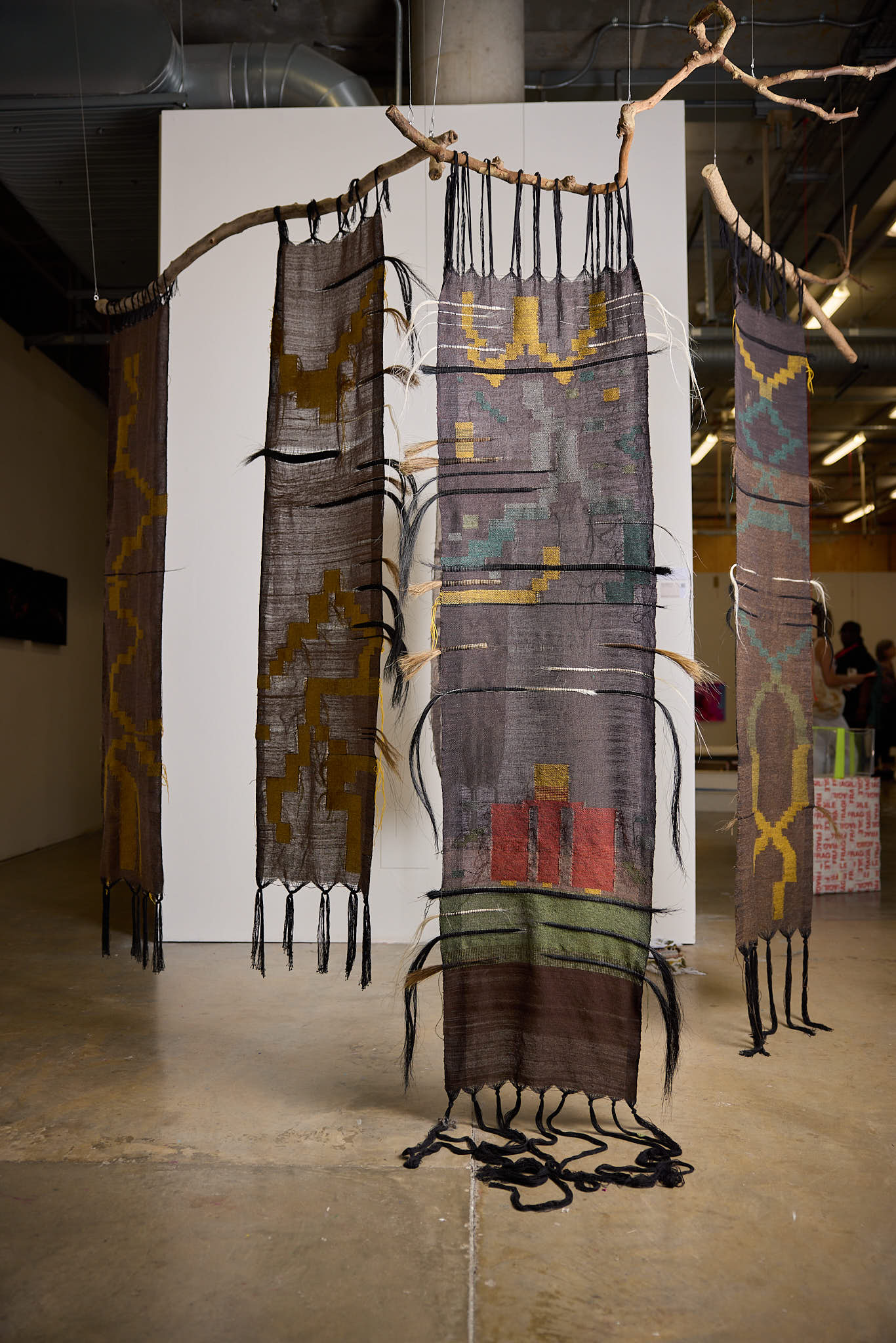 An image of woven of tapestry hanging from the ceiling
