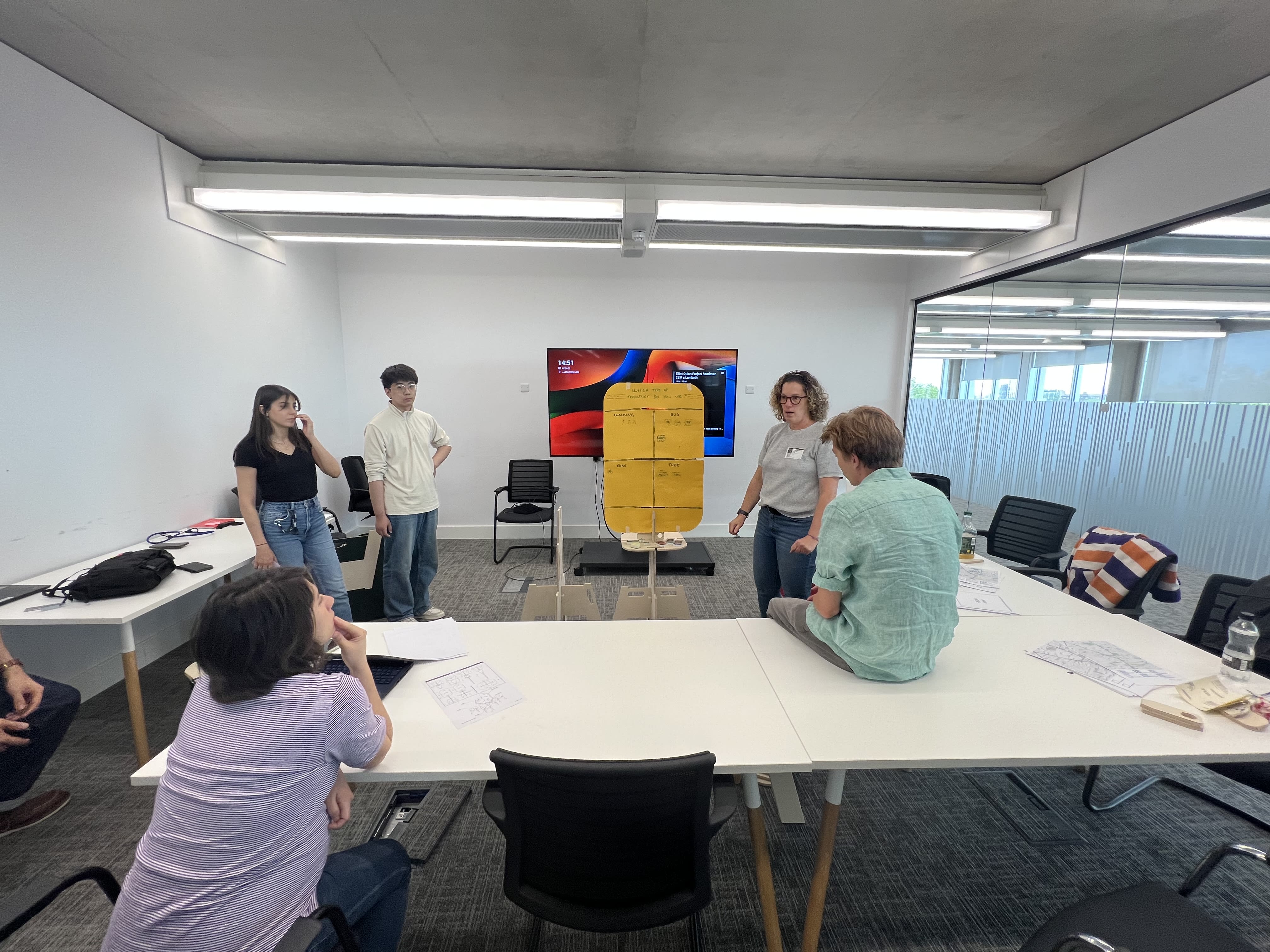 Group of students stood in a classroom while doing a presentation.