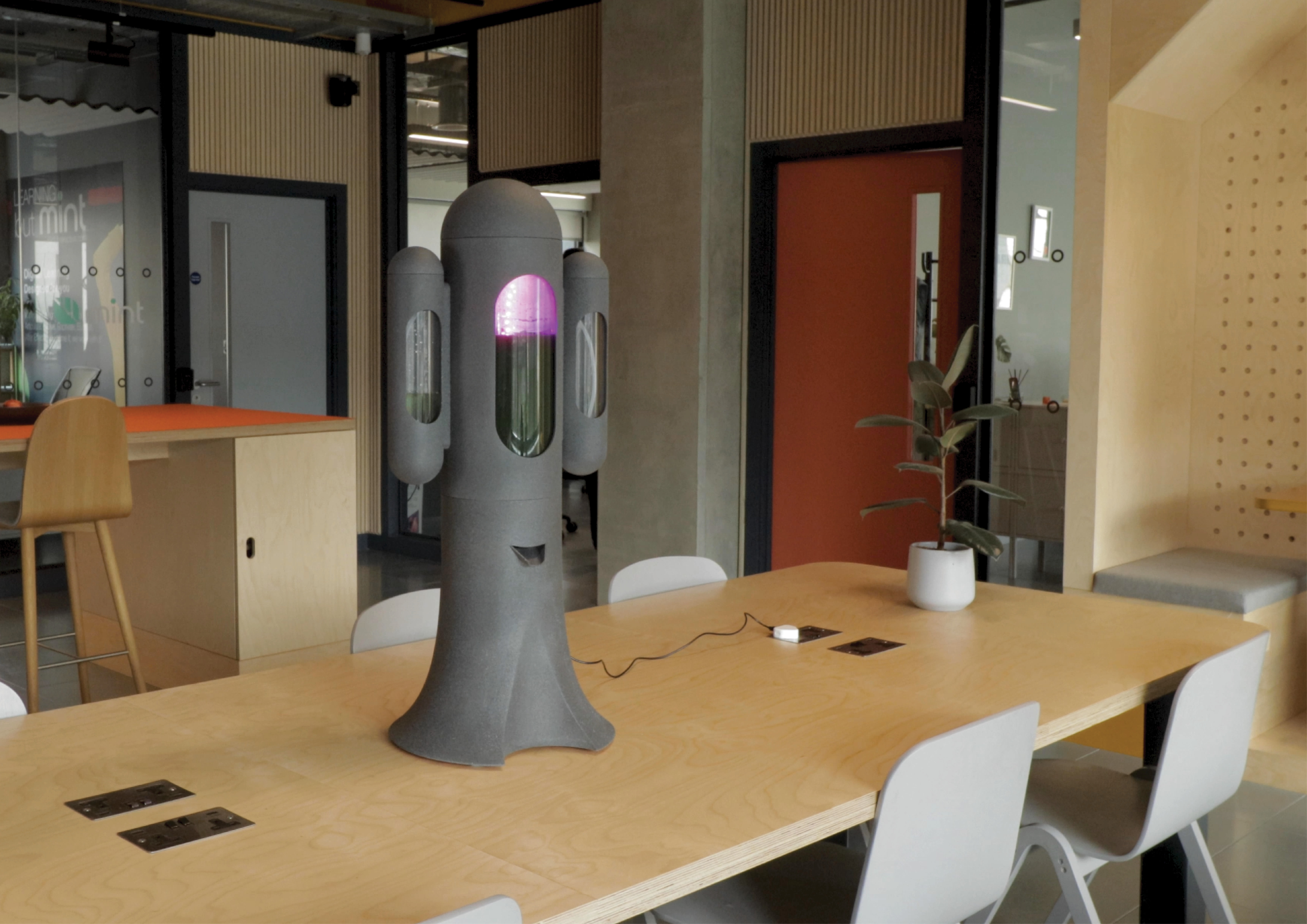 Design object placed on a brown wooden table in an office space.