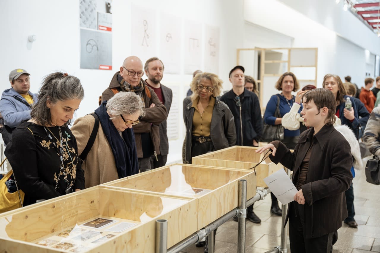 An audience gathered around work at the Unfolding Narratives exhibition. 
