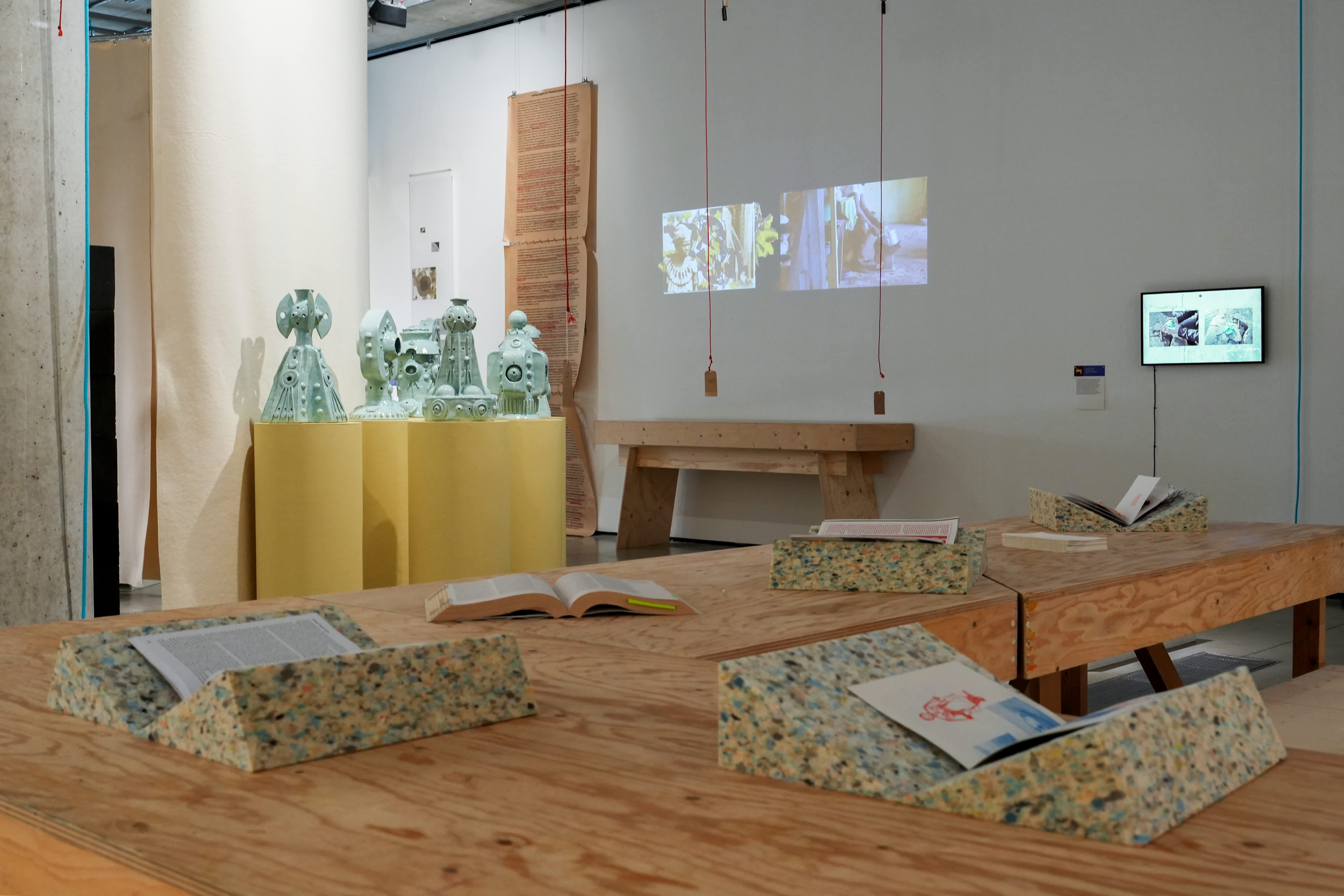 Installation view of the process exhibition with publications, screen materials and sculpture on display