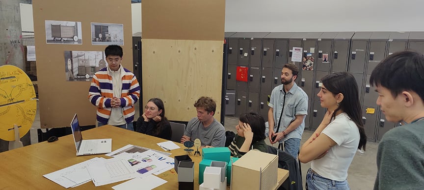 Group of people stood and sat around a table in a conference call.
