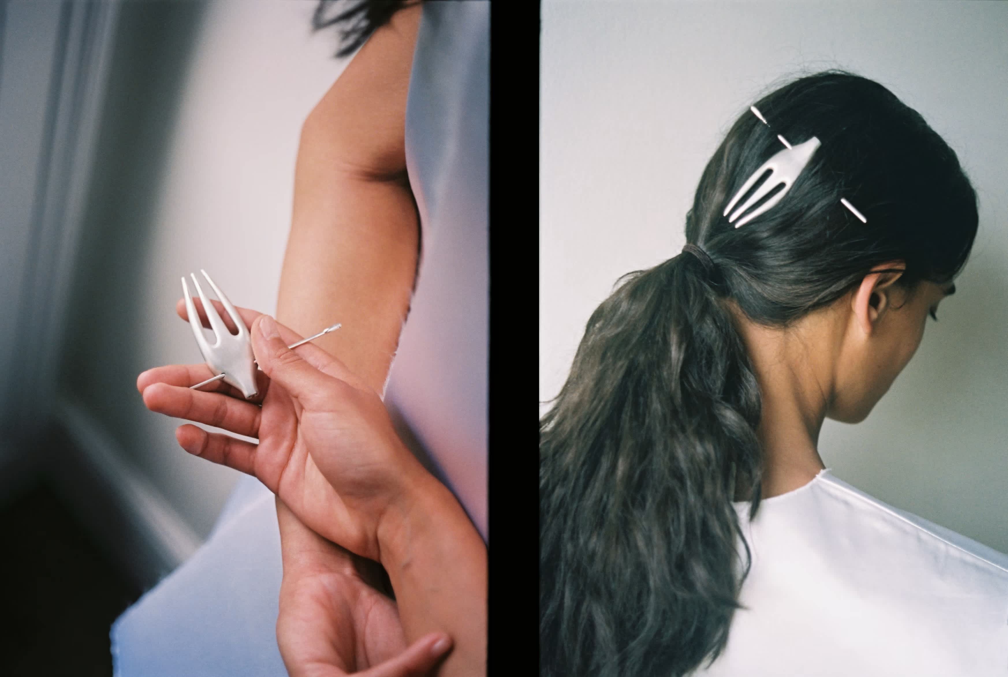 An image of a model with a jewellry piece in her hair, the piece resembles a fork