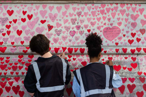 Students repaint hearts at the National COVID Memorial Wall