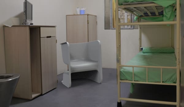 Small room with functional furniture including chair and bunk bed 