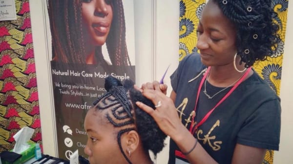 woman braiding a young girls hair
