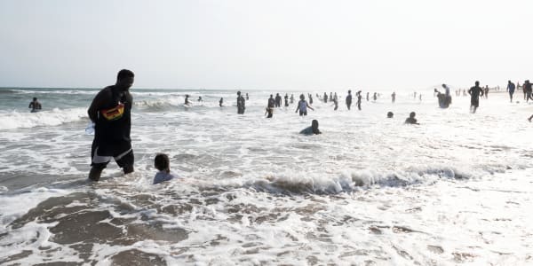 A photo of people standing and playing in the sea 