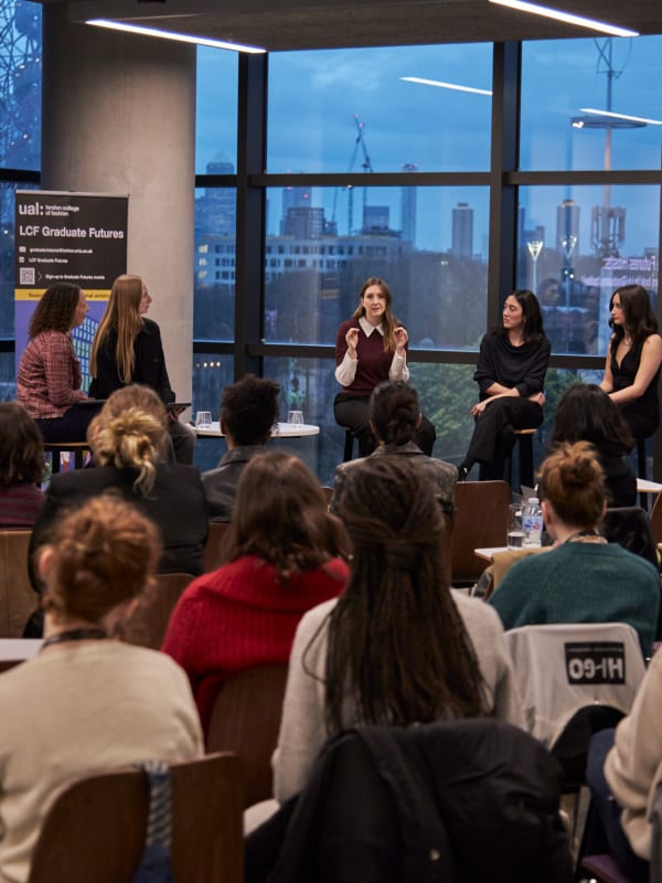 A sea of the backs of students heads, watching guest speakers at the LCF Alumni event