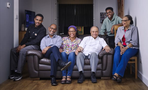 A photos of Jono and his family sat on a sofa smiling